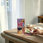 shopnathans.com Glico Pretz blueberry cheesecake pretzel sticks box with a slice of cheesecake on a wooden table