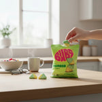 shopnathans.com Bubs Diamond Sour Tutti Frutti candy bag with a hand holding a chewy diamond-shaped gummy on a table.