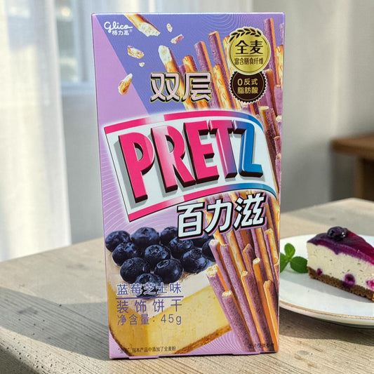 shopnathans.com Glico Pretz Blueberry Cheesecake pretzel sticks in a purple box next to a slice of cheesecake