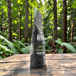 shopnathans.com Pure Infinity Botanicals Green Maeng Da Kratom capsules in a black pouch on a wooden table in a forest