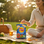 A woman enjoying shopnathans.com Lay's Italian Red Meat flavor chips during a sunny outdoor picnic