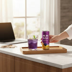 shopnathans.com Red Bull Blackberry Currant energy drink can next to a glass of purple soda with mint on a wooden tray