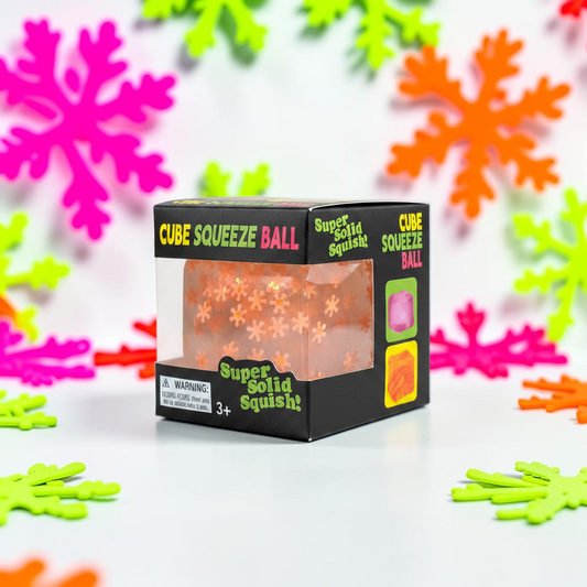 shopnathans.com squishy snowflake cube sensory toy in packaging with neon snowflake decorations in the background