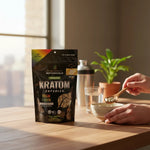 shopnathans.com Pure Infinity Botanicals Trainwreck Kratom capsules in a black pouch on a wooden table with a spoon.